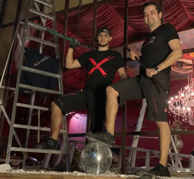 Volkan with a sledgehammer and Gregor with a crowbar on a construction site